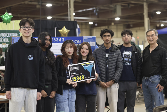 Team Blue VIII - 15343 members celebrating at a robotics competition with their award